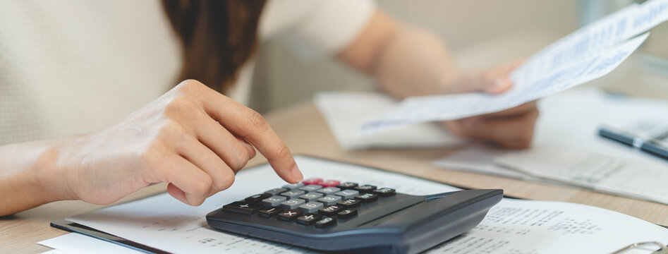 person using calculator calculating tax refund on the table