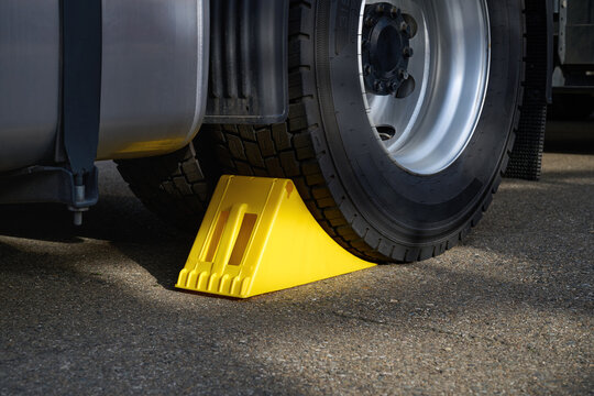 Close-up of special wheel chocks for trucks, yellow.
