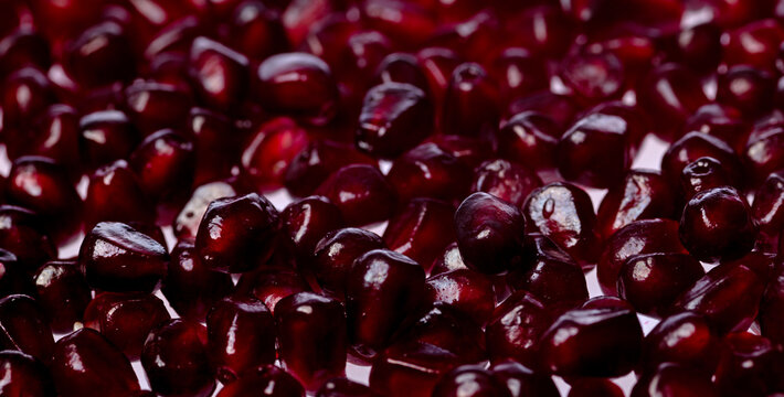 Pomegranate seeds macro background. Red ruby pomegranate arils close up background. Pomegranate arils background. Pomegranate seeds detail for background.