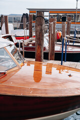 Fototapeta premium Wooden boats docked at a marina with reflections in the water on a sunny day
