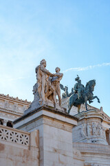 Obraz premium Statues on a building in Rome with a man on a horse under a clear sky