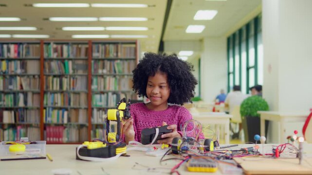 African American young girl student study on robot project in library. 