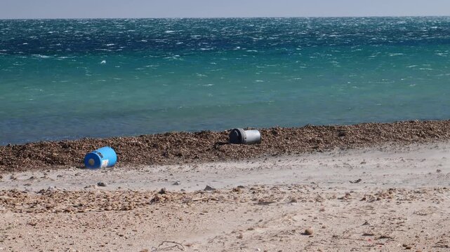 Overturned trash cans and clouds of sand in the beach due to strong winds. Slow motion x0.5. Santa Pola,Spain.