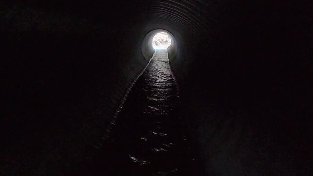 Drainage pipe with flowing water in forest