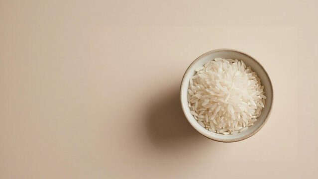 Top Down view bowl of White Rice on a Beige Background.