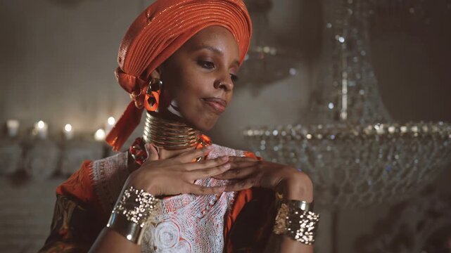 Beautiful african woman in ethnic dress and turban dancing alone in royal palace . Traditions and culture of african people, trip to africa, explore and discover new world, unique dance performance