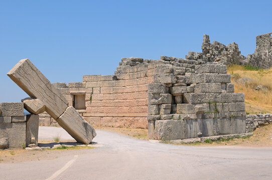 Ancient Messene city walls, historical Greek ruins collapsing. Ancient stone walls and a massive fallen block portray the historical ruins of Messene, Greece