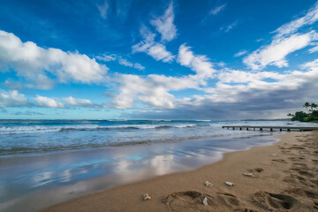 Fototapeta premium Tropical sandy beach with ocean waves and blue sky, peaceful summer seascape and travel destination concept.