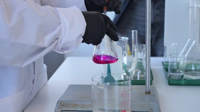 Close-up of hand holding test tube with chemical reagents in laboratory. Scientific research, chemistry education, and lab work concept.