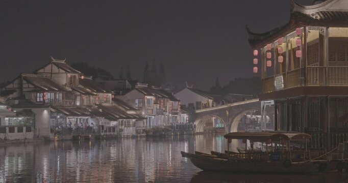Beautiful evening view with illuminated buildings and calm river reflections. Zhujiajiao, Shanghai, China