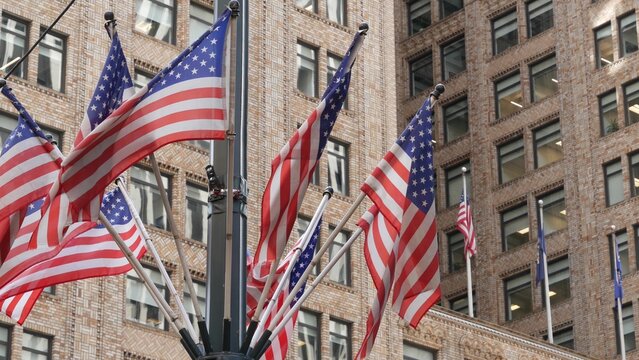 American flags near Grand Central Terminal on 42 street, New York City, Manhattan Midtown. Urban building architecture in United States. Typical offices windows of brick tower. Pershing square in NYC.