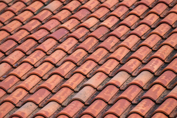 traditional, slightly weathered terracotta clay roof tiles, arranged in a repeating, wavy geometric pattern with visible aging and texture.