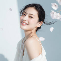 美しい肌の女性と桜が舞う春の背景