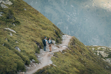 Obraz premium Two young hikers capturing photos and enjoying the breathtaking alpine landscape