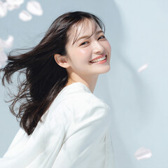 美しい肌の女性と桜が舞う春の背景