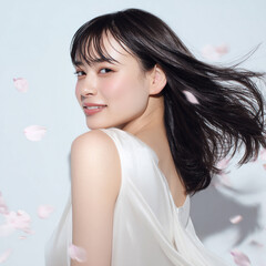 美しい肌の女性と桜が舞う春の背景