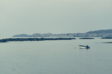 Obraz premium Small boat floating on calm bay waters