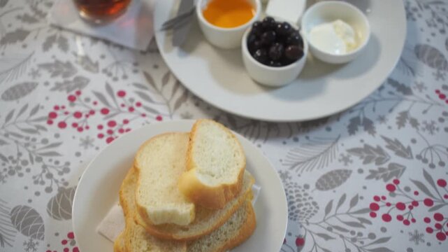 Breakfast of workers at the factory in close-up. There are eggs, cheese, butter, honey, prunes, tea and bread on the table.