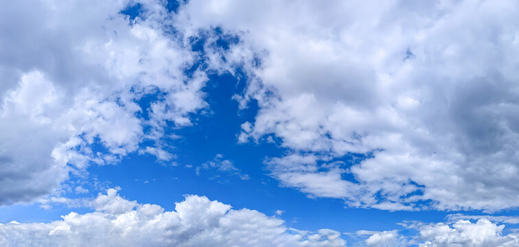 A few cumulus clouds obscure the sky, creating a window of blue sky. A bright summer sky in fine weather.