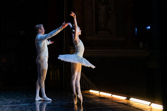 ballerina and man dancer on stage bowing and clapping.