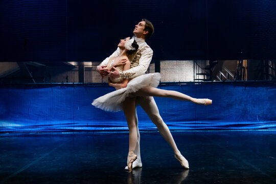 ballet duo rehearses on stage while the scenery is being assembled.