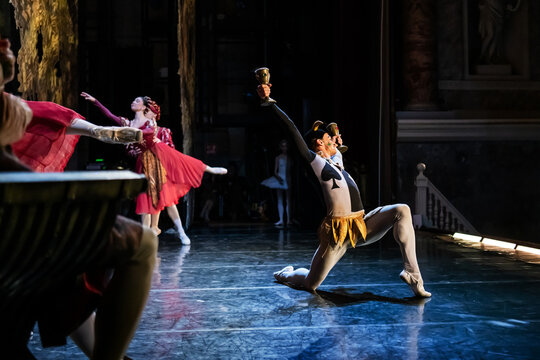 Male ballet dancer in costume on stage in theatrical dance show.