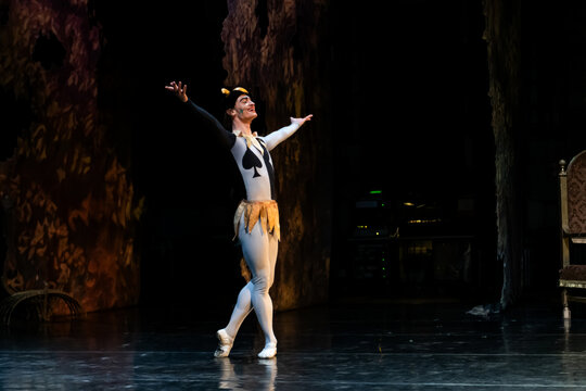 classical ballet dancer performs on stage dressed as a jester.