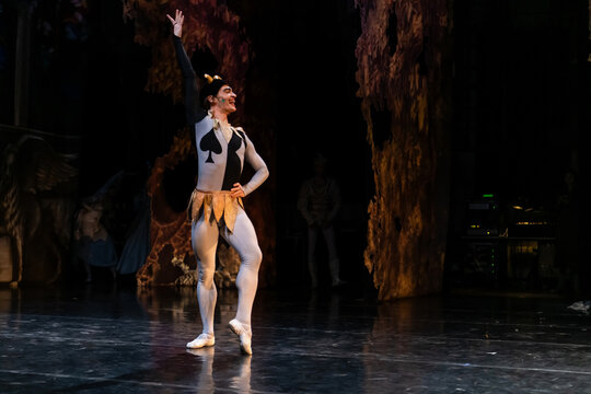classical ballet dancer performs on stage dressed as a jester.