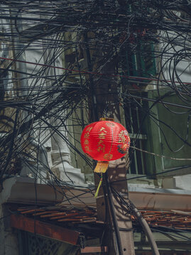 A Chinese lantern against the backdrop of electrical wires in Bangkok