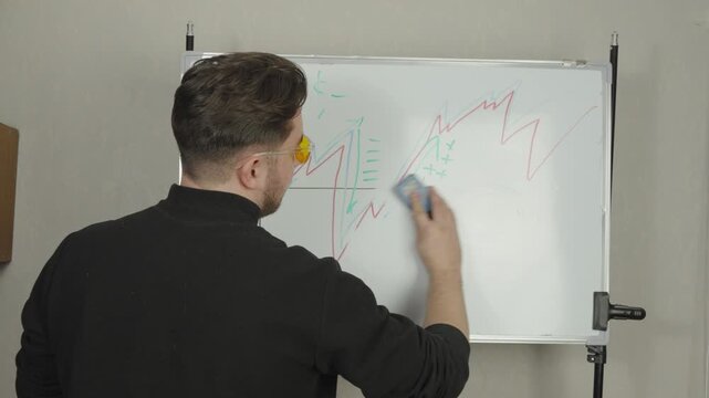 Teacher drawing graph on whiteboard during lecture in classroom