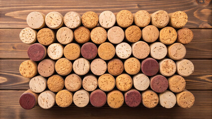 Collection of corks arranged on a wooden surface by color and texture in an indoor setting