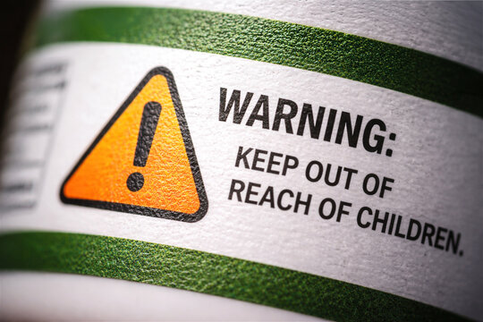 close-up view of a warning label featuring an exclamation mark symbol emphasizing the importance of keeping medication and potentially hazardous products out of reach from children for safety