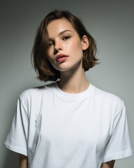 Fototapeta premium Young woman with short hair posing, wearing white t shirt, promoting natural beauty
