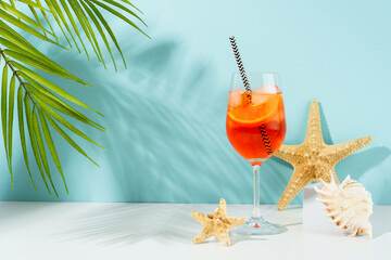 Aperol Spritz, traditional summer cocktail at blue background.