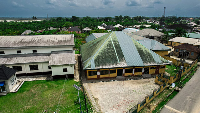 Aerial view of buildings with galvanized roofing sheets and a green lawn, reflecting the tropical sun, Abonnema, Rivers, Nigeria.