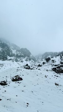 4K Vertical view of snowfall in Himalaya mountains at Chandanwari, Jammu and Kashmir, India. Nature landscape. Beautiful white snow on mountain peak during winter day.