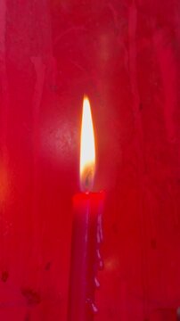 light of red candle,shining ,warm color,sign and symbol of peace and calm dowm,blurry light around.