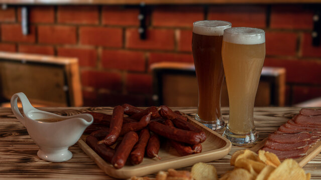 A nice evening in the pub with a glass of beer and snacks. Favorite sausages, crackers, chispa and delicious sauce. High quality photo