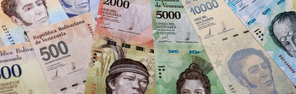 Venezuelan bolivar money bills pile on table. Venezuela banknotes of VES currency close up.