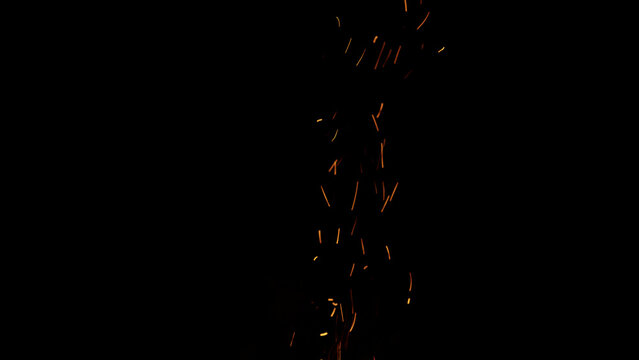 sparks and embers from campfire flying over black background