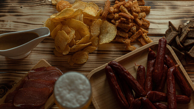 A nice evening in the pub with a glass of beer and snacks. Favorite sausages, crackers, chispa and delicious sauce. High quality photo