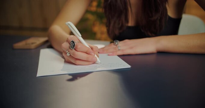 Close Up of Woman Writing Notes at Desk