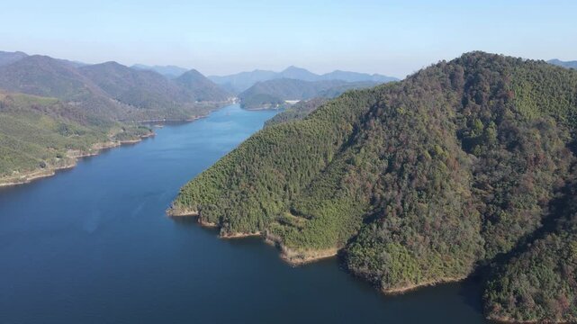 Forward Drone Flight Over Mountain Lake Surrounded by Green Hills in Anhui