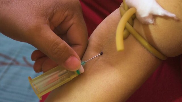 Phlebotomist Drawing Blood from Patient Arm Using Syringe for Laboratory Test