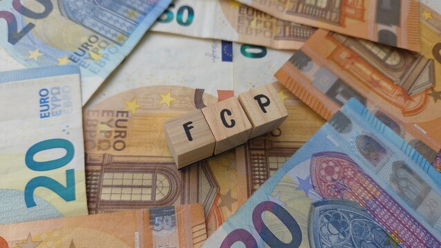 FCP acronym made of wooden letter cubes on pile of Euro banknotes. Fonds Commun de Placement (Mutual Investment Fund)