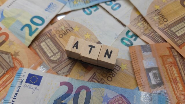 ATN acronym made of wooden letter cubes on pile of Euro banknotes.  Avantage de Toute Nature (Benefit in Kind, taxable benefits provided by employers)