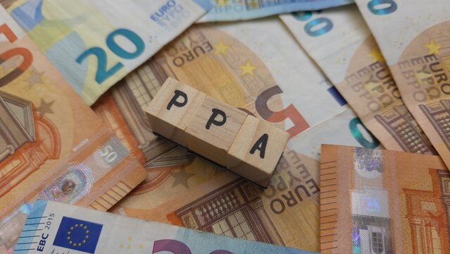 PPA acronym made of wooden letter cubes on pile of Euro banknotes. Plan de Pensions d'Entreprise (Company Pension Plan)