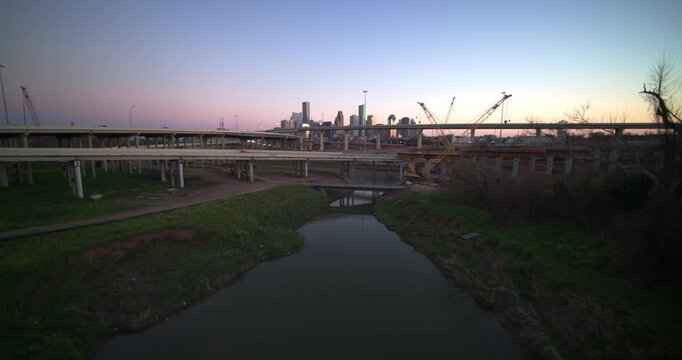 Ascending wide angle drone shot revealing Downtown Houston from the Buffalo Bayou and I-45 North and I-10 West freeway