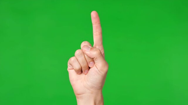 A hand with the index finger pointing up on a green screen, perfect for chroma key compositing and digital projects.