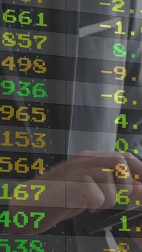 Vertical video: Trader tapping tablet and swiping pen causing market ticker while viewing stocks